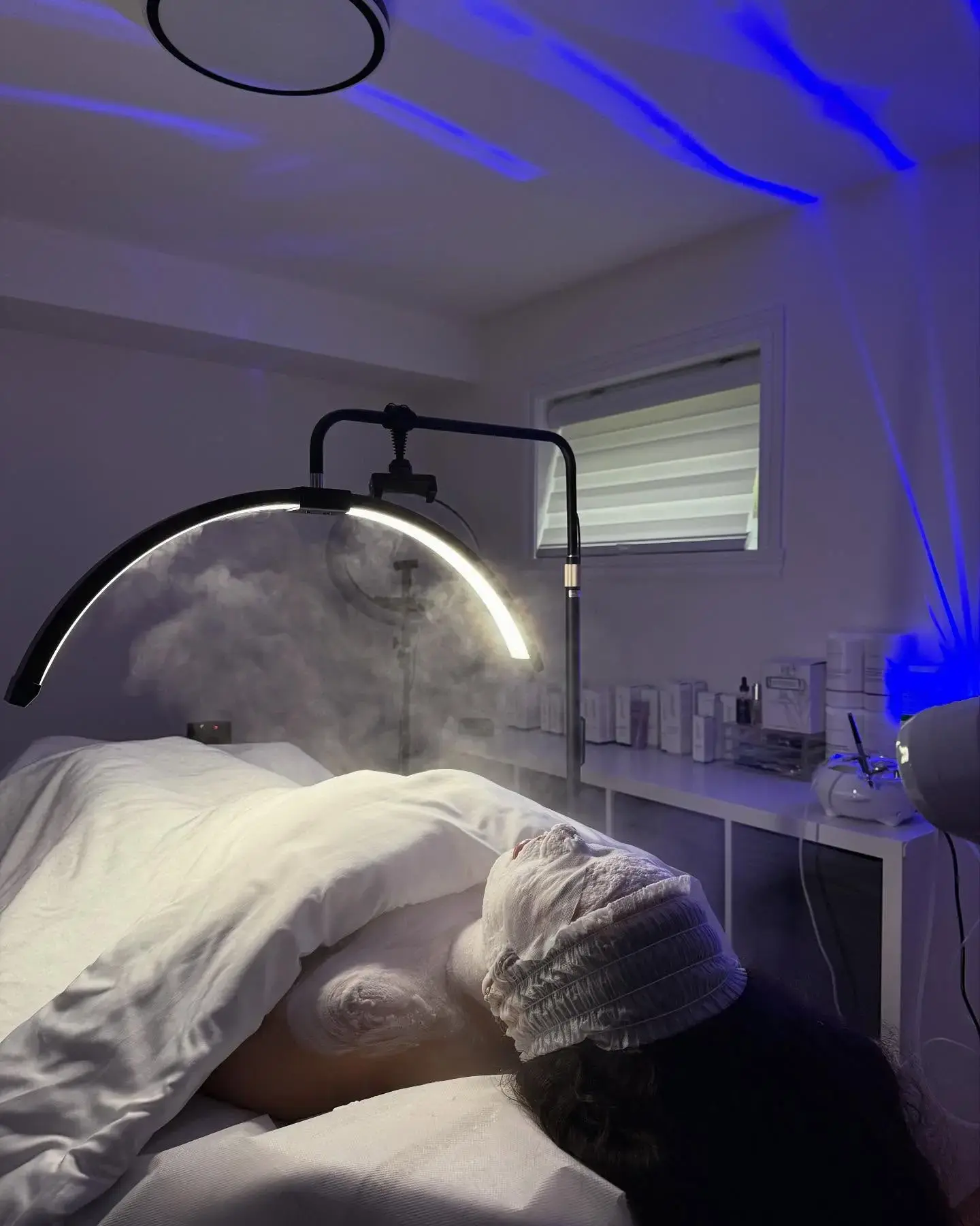 Soin du visage en cours : masque, vapeur et lumière LED sur une cliente chez Soin Beauté Rosa à Laval, réalisé par Rosa.